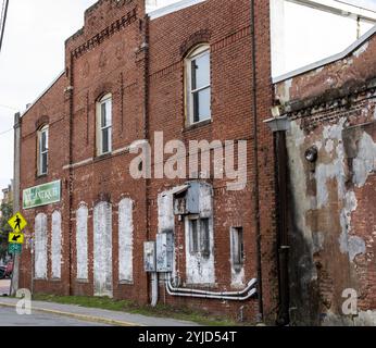 Savannah, Georgia, USA - 20. Februar 2024: Ein verwittertes Ziegelbauwerk mit verblasster Farbe und Vintage-Details entlang einer Stadtstraße. Stockfoto