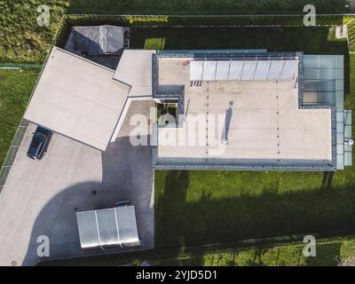 Blick aus der Luft auf ein modernes Haus mit Solarpaneelen auf dem Dach. Moderne Architektur, Vorstadthaus, ländliches Wohnen, luxuriöser Lebensstil. Erneuerbar Stockfoto