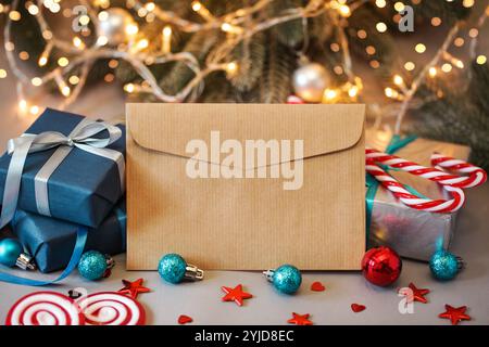 Leerer Papierumschlag, Weihnachtsgeschenke für Männer. Blaue Geschenkbox, Süßigkeiten auf weihnachtlichem Hintergrund. Geschenk für Ehemann. Geschenk für ihn. Mock-Up Stockfoto