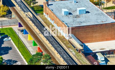 Aus der Vogelperspektive der farbenfrohen Hochbahngleise und des Industriegebäudes Stockfoto
