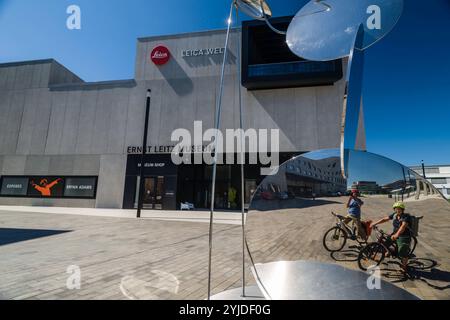 2 Radfahrer spiegeln sich in Spiegeln vor dem Museumsgebäude der Firma Ernst Leitz, Kamerahersteller der Leica Kamera, Wetzlar, Hessen, Deutschland. Firmenkomplex Leitz Wetzlar *** 2 Radfahrer im Spiegel vor dem Museumsgebäude der Firma Ernst Leitz, Hersteller der Leica-Kamera, Wetzlar, Hessen, Deutschland Leitz Wetzlar Firmenkomplex Stockfoto