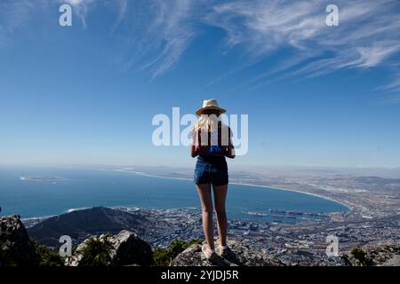 Ein Mädchen, das über kapstadt auf der Spitze des Tafelbergs blickt Stockfoto