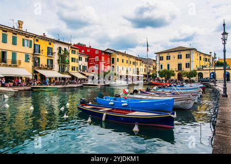 LAZISE, ITALIEN – 21. AUGUST 2024: Porto Lazise am Gardasee mit seiner historischen Uferpromenade, den ruhigen Gewässern und den am Kai angedockten Booten spiegelt das wider Stockfoto