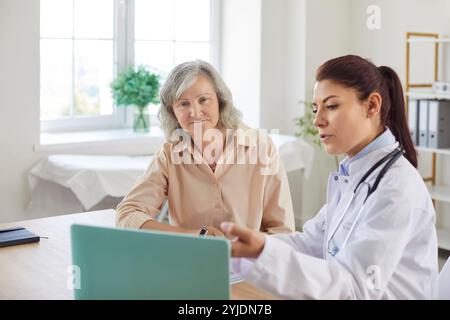 Ärztin, die ältere Frau medizinisch konsultiert und den Behandlungsplan in der Klinik bespricht. Stockfoto