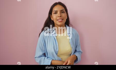 Schöne brünette junge Frau auf rosafarbenem Hintergrund, die selbstbewusst und attraktiv aussieht Stockfoto