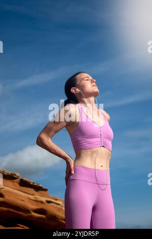 Sportliche Frau, die die Sonne genießt, sich nach dem Training ausruht und Vitamin D erhält Stockfoto