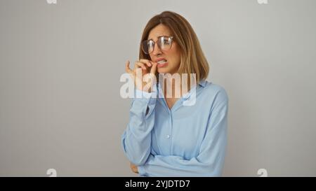 Frau beißt Nägel blonder Erwachsener mit Brille, die nervös isoliert weißen Hintergrund aussieht Stockfoto