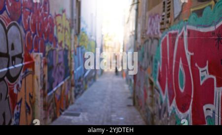 Der unscharfe Blick auf die mit Graffiti bedeckten Gassen lässt auf urbane Street-Art-Szene mit lebhaften Farben schließen, die defokussierte Hintergründe betonen, die typisch für Ghettocul sind Stockfoto