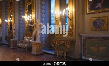 Verschwommenes Bild, das das verzierte und opulente Innere der galleria doria pamphilj mit Statuen und goldenem Dekor unter warmer, defokussierter Beleuchtung zeigt. Stockfoto