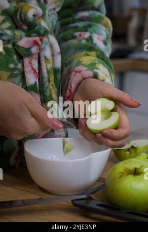 Eine Frau entfernt den Kern von den Äpfeln. Sie macht Apfelfrucht-Leder. Nahaufnahme. Stockfoto