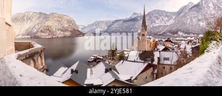 Panoramablick auf das Dorf Hallstatt mit schneebedeckten Dächern mit Blick auf den Hallstätter See und die umliegenden Berge in den österreichischen Alpen Stockfoto