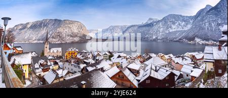 Panoramablick auf das Dorf Hallstatt mit schneebedeckten Dächern mit Blick auf den Hallstätter See und die umliegenden Berge in den österreichischen Alpen Stockfoto