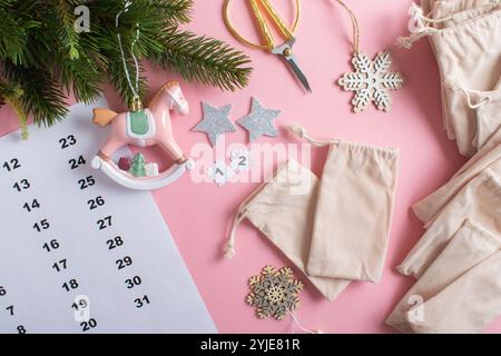 Weihnachts-Adventskalender mit Samtbeuteln auf hellrosa Hintergrund Stockfoto