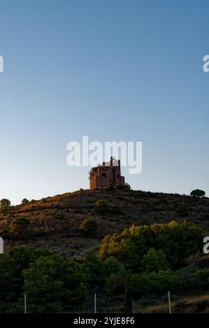 Castillo de la Mota, beleuchtet vom warmen Glanz des Sonnenuntergangs, hoch auf einem Hügel in Alhaurín el Grande Stockfoto