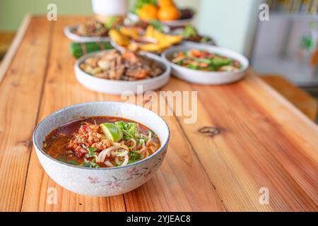 Khao Soi Chiang Tung wird in einer Schüssel mit klebrigen Reisnudeln und einer geschmackvollen Suppe nach Chiang Tung serviert. Das köstliche Khao Soi Chiang Tung i Stockfoto