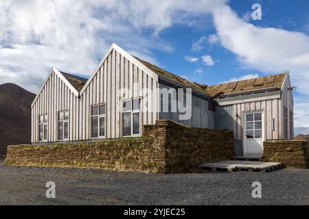 Traditionelles isländisches Holzgebäude mit Rasendach und grauen Holzpaneelen. Stockfoto