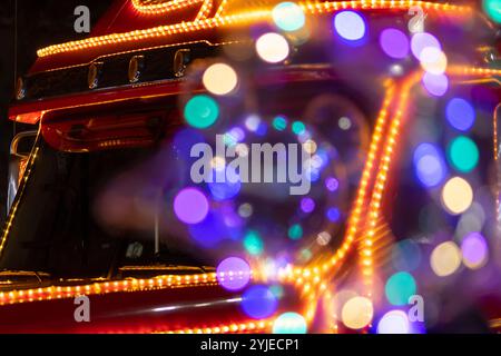 Roter Weihnachtsmann-Truck, bunte Lichter, Nahaufnahme, selektiver Fokus. Konzept: Weihnachten und Silvester, Feiertag. Stockfoto