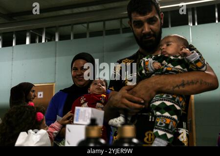 Beirut, Beirut, Libanon. November 2024. Ibrahim (R) und Fatima, beide mit ihren Töchtern Zeinab und Taline, warten auf die Impfung ihrer Kinder in einem Zentrum, in dem mindestens 700 Menschen untergebracht sind, die nach der Flucht vor israelischen Angriffen Zuflucht in Beirut suchten. Die libanesischen Behörden, Gemeinden und humanitären Organisationen kämpfen darum, über eine Million Menschen, die vor den Luftangriffen und Invasionen von IsraelÃ¢â‚¬â„¢im Süden fliehen, zu unterbringen und ihnen das notwendige Leben zu bieten. (Kreditbild: © Marwan Naamani/ZUMA Press Wire) NUR REDAKTIONELLE VERWENDUNG! Nicht für kommerzielle ZWECKE! Stockfoto