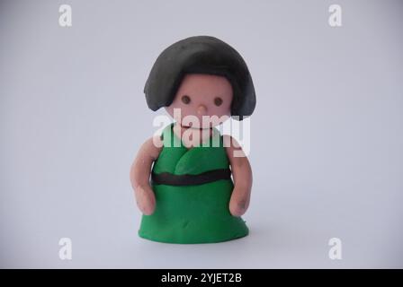 3D-Rendering in stilisiertem Ton einer jungen Frau mit dunklem Haar und grünem Kleid. Stockfoto