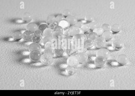Transparente Kunststoffpellets auf weißer Oberfläche Stockfoto