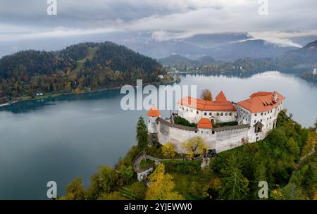 Luftdrohenszene der mittelalterlichen Burg Bled, die auf einer Klippe mit Blick auf den See Bled und die julischen alpen im Herbst, slowenien, thront Stockfoto