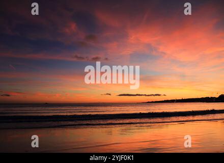 Sonnenuntergang mit dramatischem Himmel über einem leeren Strand an der Riviera von Lissabon, zwischen Oeiras und Cascais. Lissabon, Portugal. Stockfoto