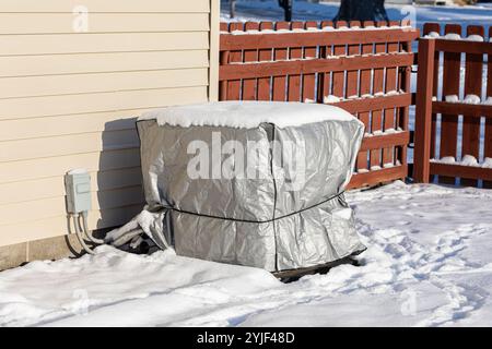 Haus-Klimaanlage mit Schutzabdeckung und Schnee im Winter. Klimaanlage, Heizung, Klimaanlage, Service, Wintersport und Wartungskonzept. Stockfoto