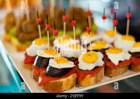 Kleine Canape-Sandwiches, die aus einem Kreis aus gebratenem Schwarzpudding und Spiegelei zubereitet werden, werden für das Festmahl zubereitet Stockfoto