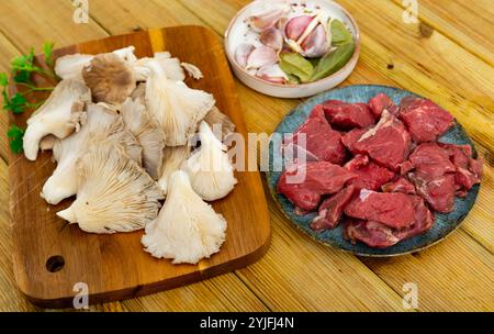 Rohe Kalbfleischstücke, Gewürze und Austernpilze. Stockfoto