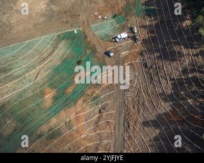 Strohwattles auf einem Hügel als Erosionskontrolle auf einer Baustelle und Hydrosaat in Kalifornien, USA aus der Vogelperspektive über Drohnen. Stockfoto