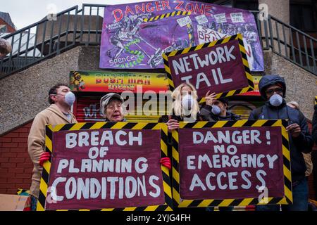 London, Großbritannien. Februar 2018. Der Künstler Andrew Cooper zeigt Aysen Dennis aus dem Aylesbury Estate seine Skulptur von den Lambeth Councillors, die für die soziale Säuberung verantwortlich sind. Die Wahlkämpfer begehen den dritten Jahrestag der Ankündigung von Network Rail, die Brixton Arches mit einer Kundgebung und einem dreiminütigen Schweigen zu erneuern. Das Gebiet und seine kleinen Händler, die vertrieben wurden (einige kämpfen immer noch um den Rest), wurden als das „Herz von Brixton“ bezeichnet. Die Arbeiten sollten bis 2016 abgeschlossen sein, sollen aber erst morgen beginnen, und der Save Brixton AR Stockfoto