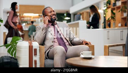 Business, Hotel und Mann in der Lounge mit Telefonanruf, Lächeln und Gepäck in der Lobby für Kommunikation. Reise, Buchung und glücklicher Geschäftsmann an der Rezeption Stockfoto