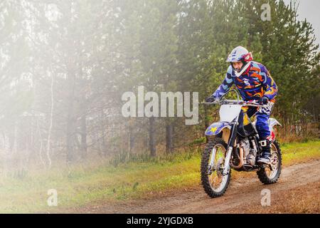 Ein Mann fährt mit einem Enduro-Motorrad durch. Farbausrüstung Stockfoto