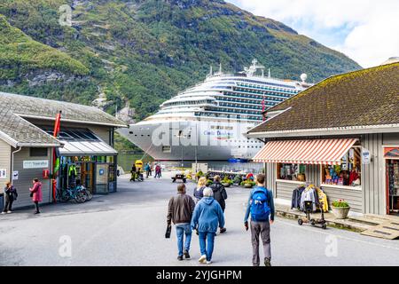 Costa Diadema Traumklasse Kreuzfahrtschiff im Hafen im Geiranger Dorf mit Besuchern, die in den lokalen Geschäften und Geschäften stöbern Stockfoto