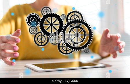 Digitales Tablet mit Teamkonzept zwischen den Händen einer Frau Im Hintergrund Stockfoto