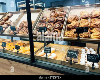 Kiew, Ukraine - 14. November 2024: Eine verlockende Bäckerei bietet eine Auswahl an frisch gebackenem Gebäck und süßen Leckereien, Zimtrollen, Croissants und Muffi Stockfoto