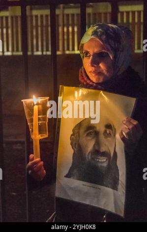 London, Großbritannien. Januar 2018. Aisha Maniar, Organisatorin der London Guantánamo Campaign, hält eine Kerze und ein Foto von Häftlingen bei der Kerzenlichtwache. Die US-Botschaft bezeichnete den 16. Jahrestag des illegalen Folterlagers in der Guantanamo Bay, in dem noch 41 Gefangene festgehalten werden, hauptsächlich ohne Anklage oder Gerichtsverfahren und die meisten mit dauerhaften Verletzungen durch Folter, die ihre Freilassung für die US-Behörden (und möglicherweise Großbritannien) peinlich machen würden. Die Demonstranten zündeten vor dem Botschaftszaun Kerzen an, die „GITMO“ buchstabierten, und standen dann mit Kerzen und großen Fotos Stockfoto