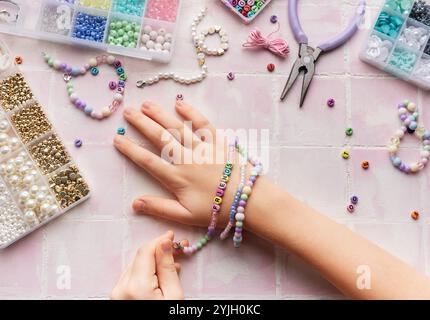 Kind kreiert handgemachten Schmuck und genießt ein entspannendes Hobby Stockfoto