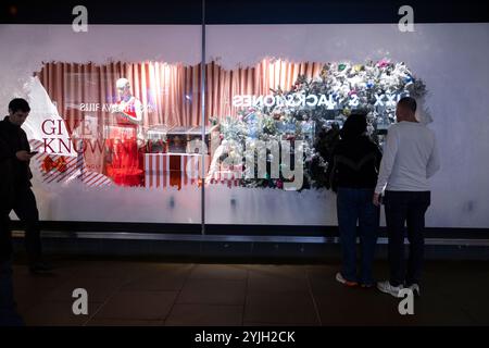 Weihnachtseinkäufer genießen die John Lewis 2024 Weihnachtsfenster zu Beginn der Feiertage entlang der Oxford Street, Großbritanniens geschäftigster Straße. Stockfoto