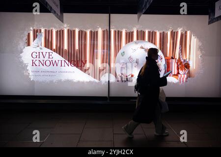 Weihnachtseinkäufer genießen die John Lewis 2024 Weihnachtsfenster zu Beginn der Feiertage entlang der Oxford Street, Großbritanniens geschäftigster Straße. Stockfoto