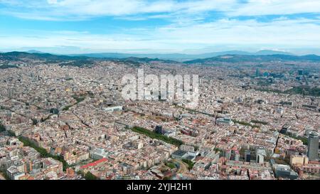 Aus der Vogelperspektive Barcelonas pulsierendes Stadtbild unter einem klaren blauen Himmel, das architektonische Vielfalt und dynamische Zersiedelung zeigt Stockfoto