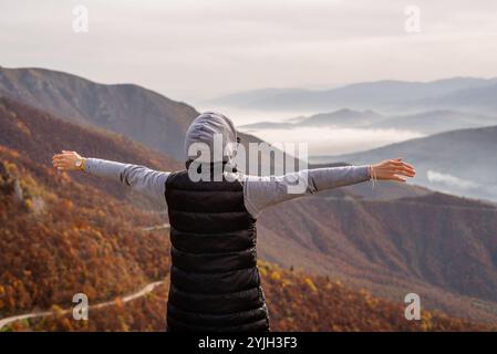 Glückliche Reisende Frau, die es genießt, Hand offen auf den Berg zu steigen. Der Begriff der freien Freiheit. Stockfoto