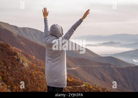 Eine glückliche Frau, die es genießt, Hand auf den Berg zu heben. Der Begriff der freien Freiheit. Stockfoto