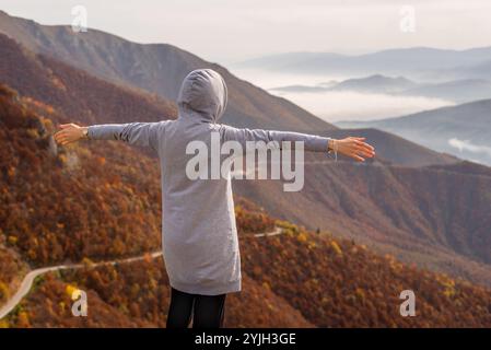 Glückliche Frau, die es genießt, Hand offen auf den Berg zu steigen. Der Begriff der freien Freiheit. Stockfoto
