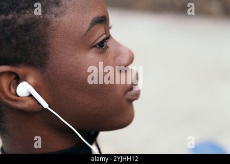 Schwarze Frau, die Musik mit Ohrhörern hört Stockfoto