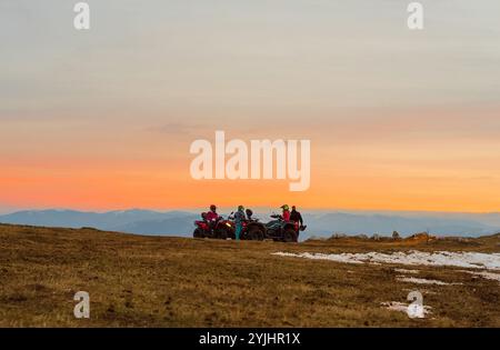 Gruppe von Freunden, die Quad Quad Quad Quad Off Road auf dem Berg bei Sonnenuntergang Abenteuer Reise. Stockfoto