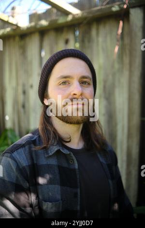 Porträt eines jungen Mannes, der eine Mütze und ein Flanell-Shirt trägt Stockfoto
