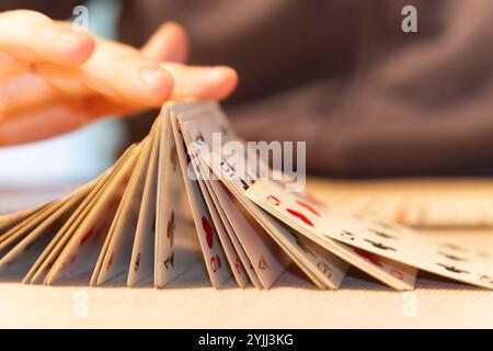 Nahaufnahme der Hände eines Jungen, die mit Spielkarten spielen Stockfoto