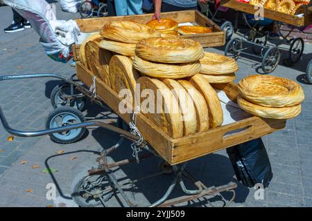 Ein Wagen voller Brot wird die Straße runter geschoben Stockfoto