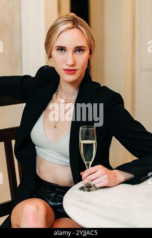 23 Jahre alte weiße Frau in schwarzem Blazer mit Weinglas Stockfoto